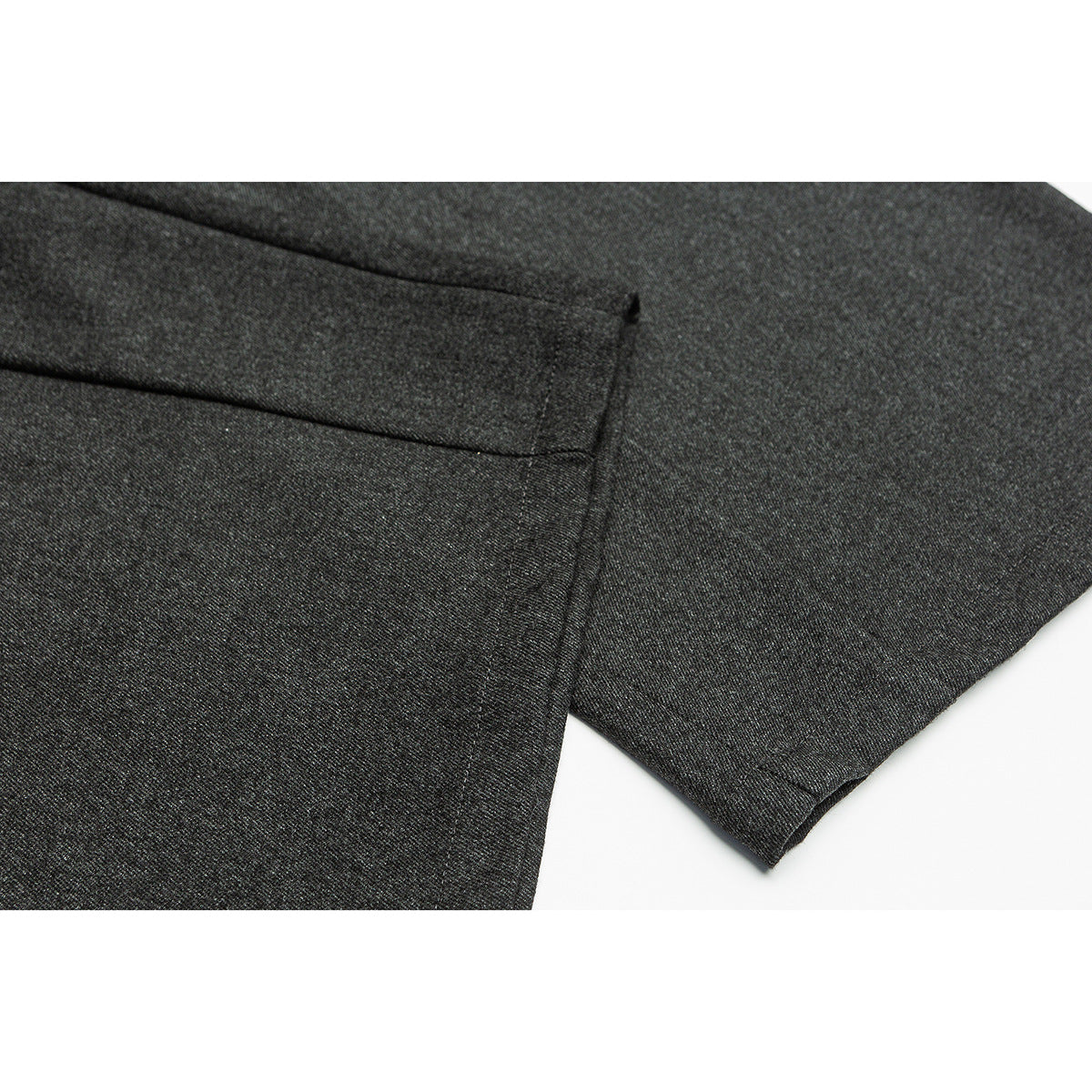 Close-up of charcoal gray trousers showing a welt pocket, fabric texture, and stitched hem.