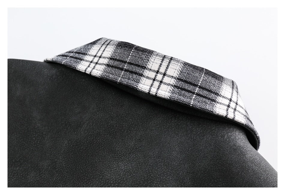 Close-up of a black garment with a folded black-and-white plaid collar.