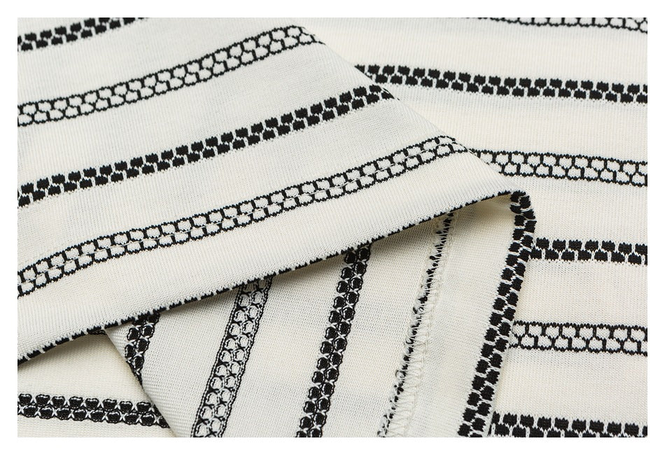 Close-up of striped ivory fabric folded to show the seam and finished edge.