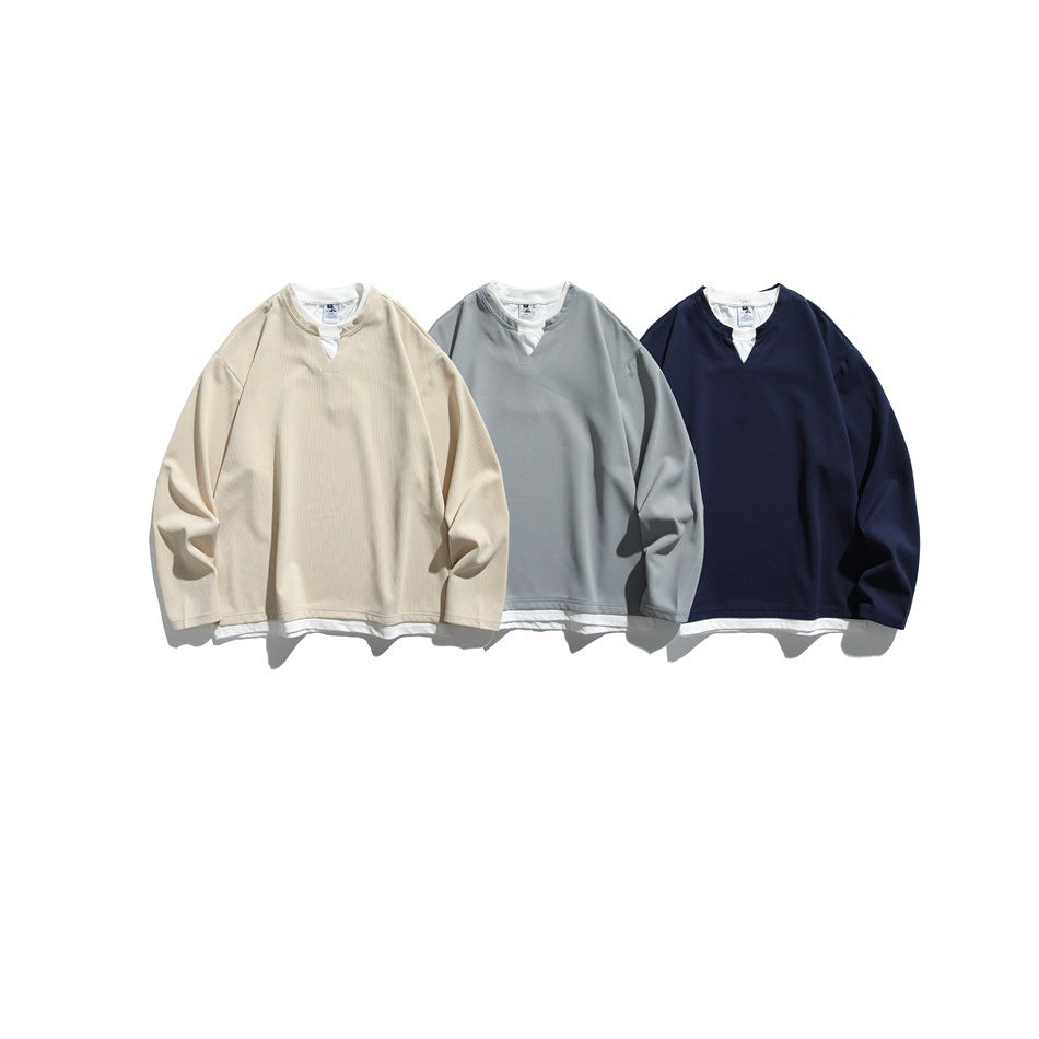 Three long-sleeve tops with notched necklines in cream, gray, and navy, shown from the front.