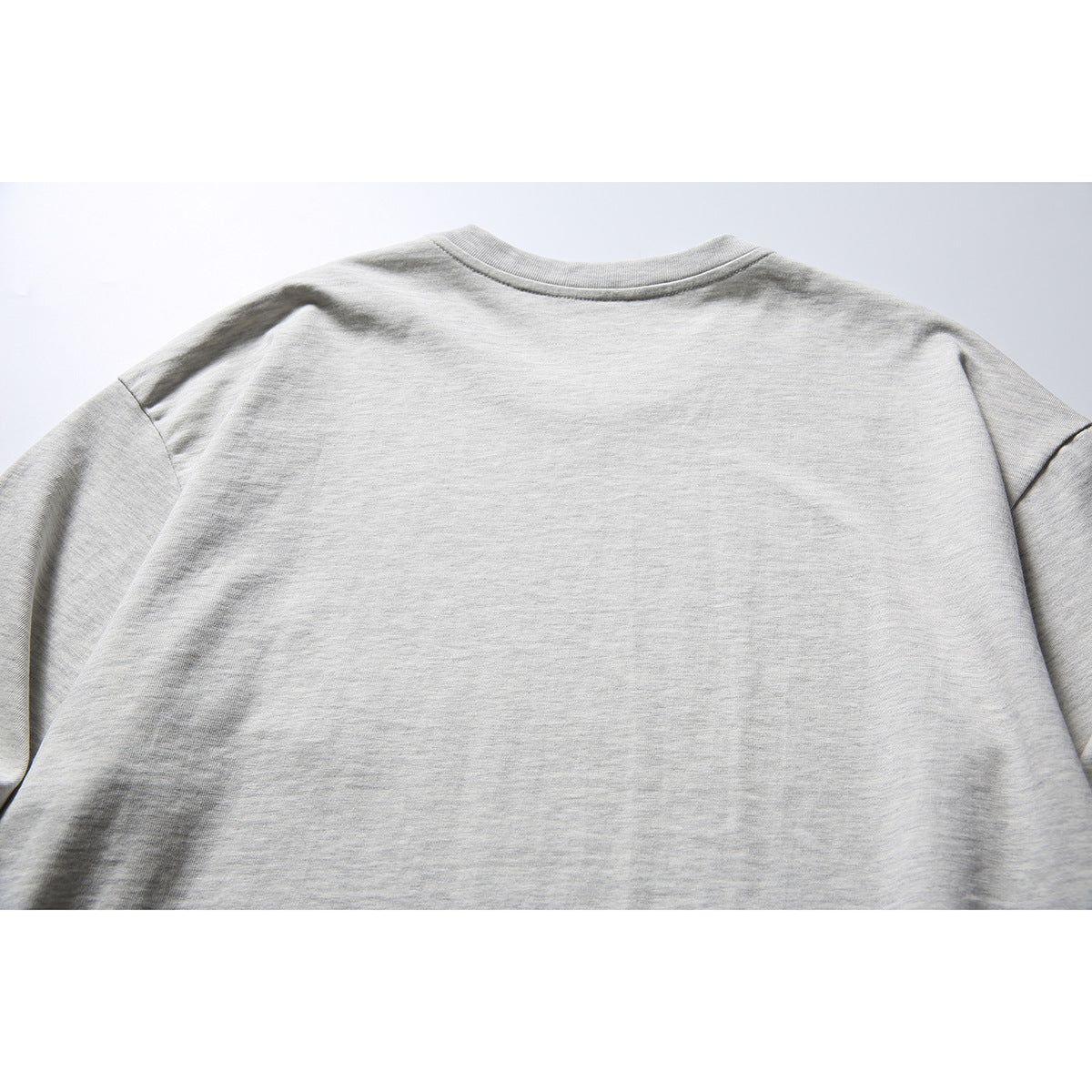 Back view of a light gray long-sleeve crewneck shirt.
