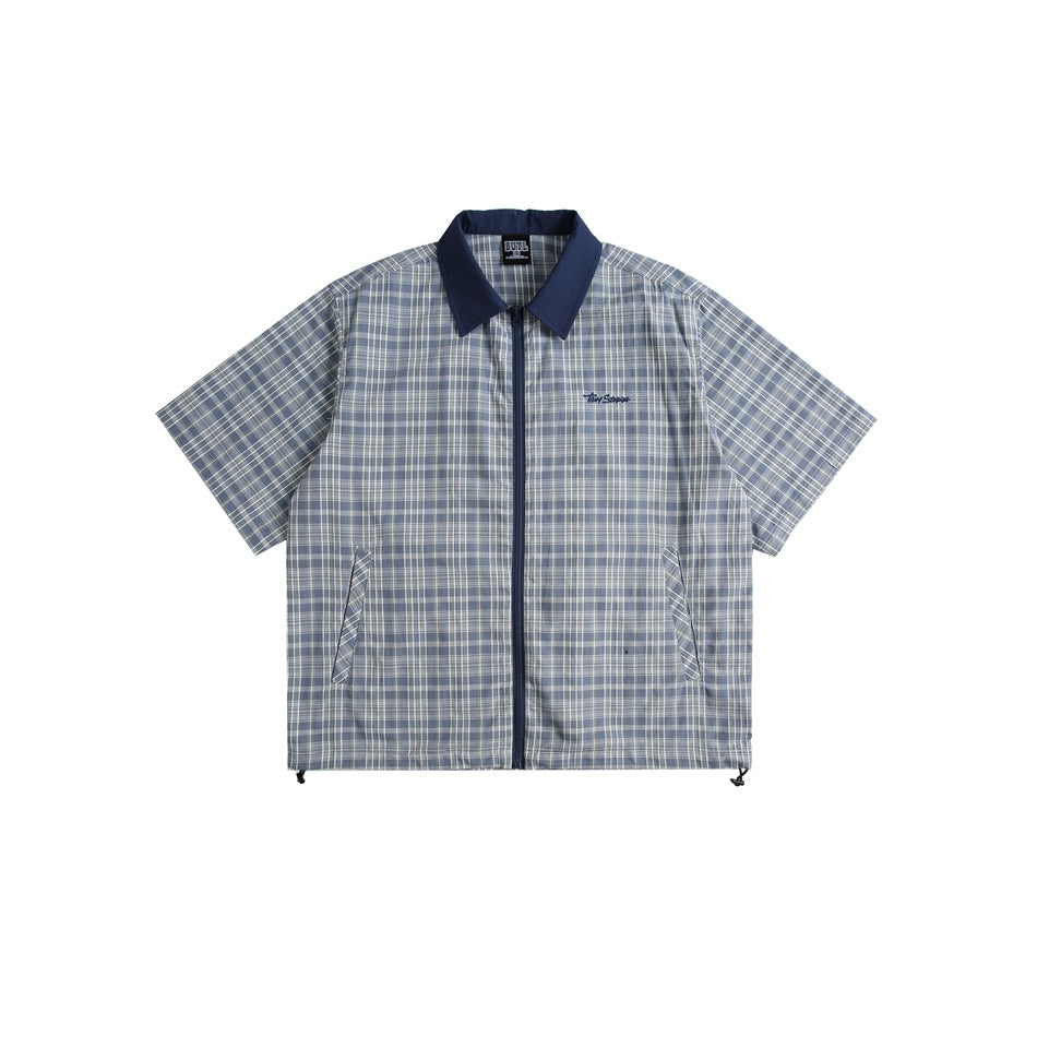 Blue-gray plaid short-sleeve zip-front shirt with navy collar, slanted pockets and hem drawcords, flat lay