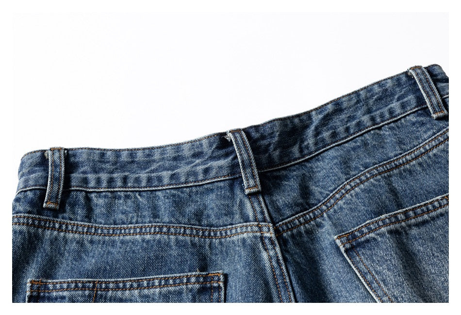 Close-up of the blue jeans waistband, belt loops, and upper back pockets.
