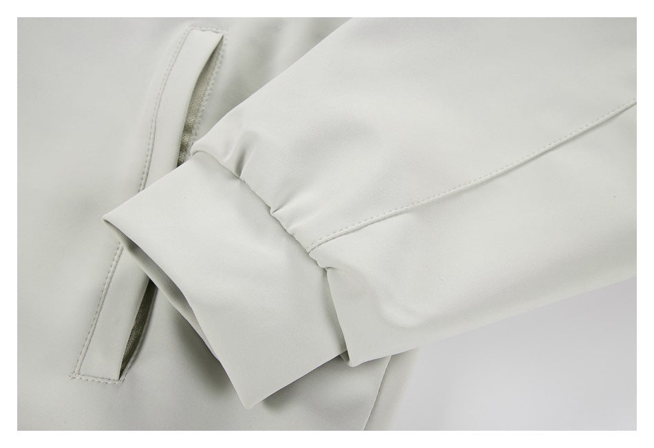 Close-up of a light gray sleeve and cuff beside a slanted welt pocket.
