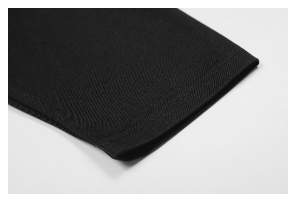 Close-up of a black garment hem with visible double stitching.