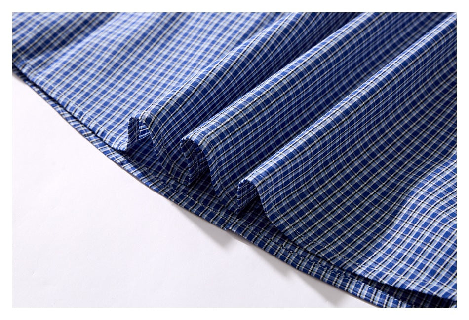 Close-up of blue checked shirt fabric folded into soft ridges.
