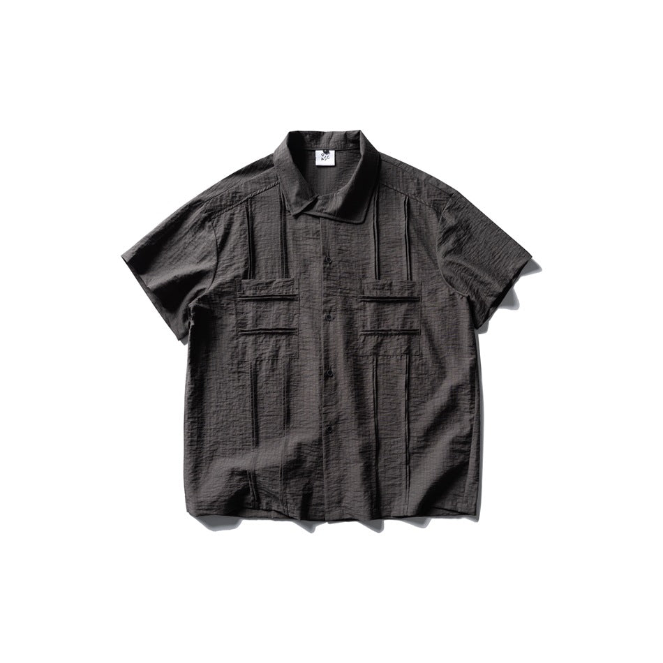 Dark gray short-sleeve textured button-up shirt with two pleated chest pockets, flat lay front view