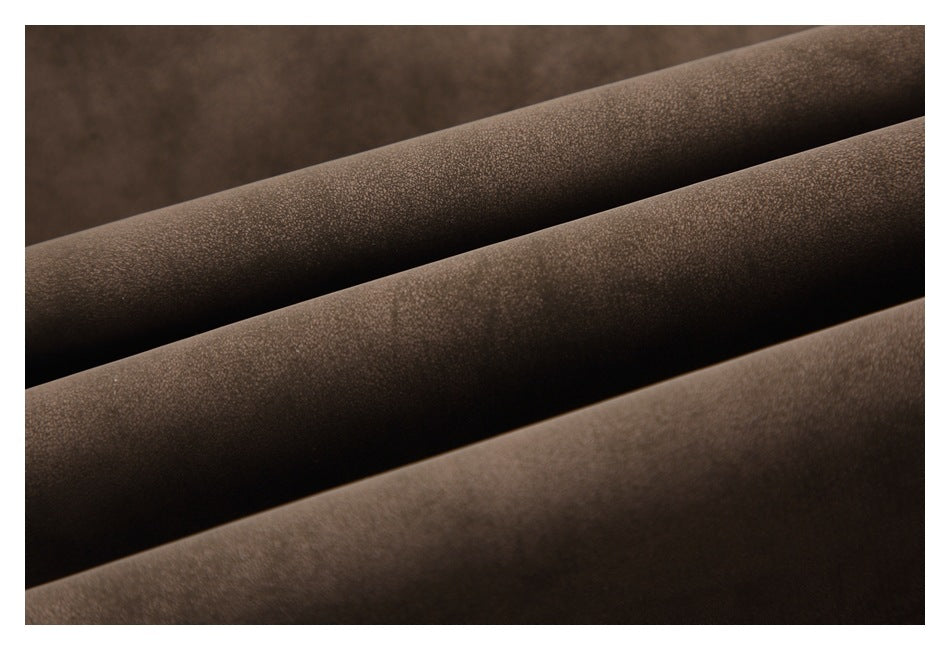 Close-up of brown fabric arranged in parallel folds, showing its fine surface texture.