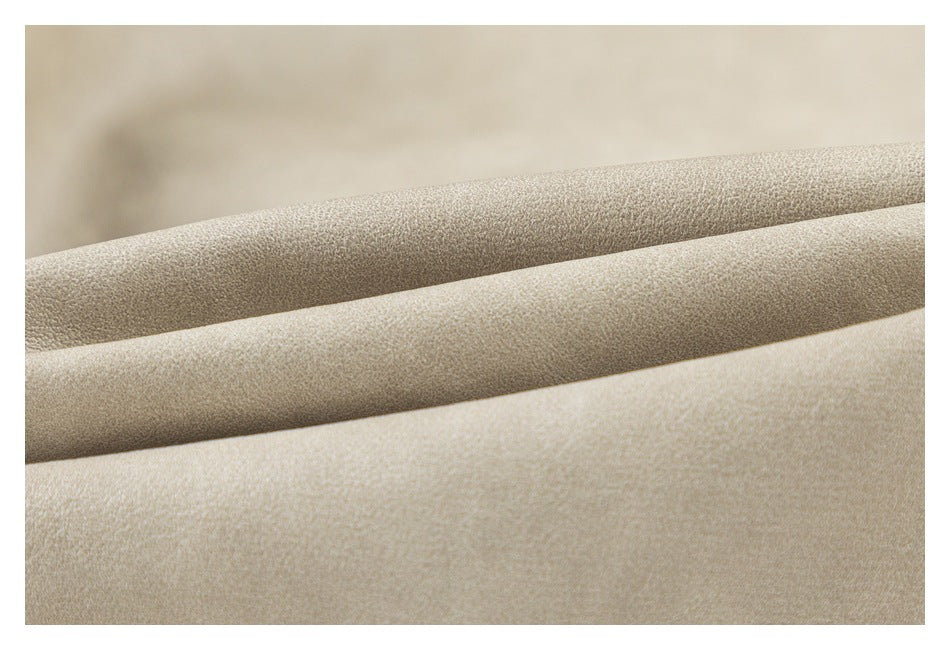 Extreme close-up of the softly textured light taupe coat surface and folded edge.