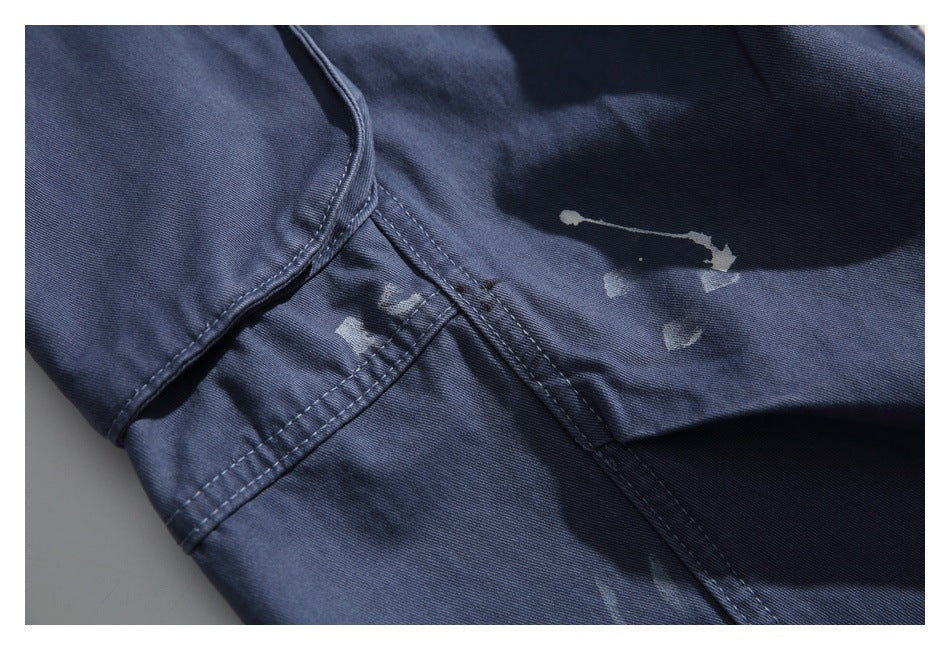 Close-up of navy garment seams and scattered pale distressed marks.