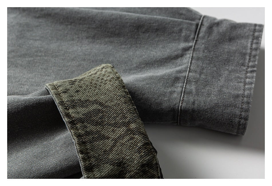 Close-up of a dark gray garment sleeve and cuff, showing the turned-back cuff and stitching.