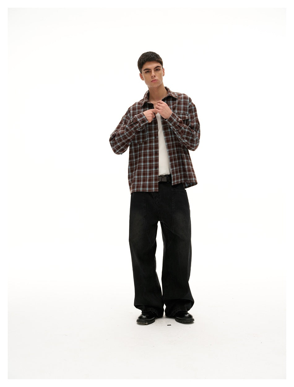 Full-length model wearing a brown plaid button-up over a white tank, with loose black trousers and black shoes.
