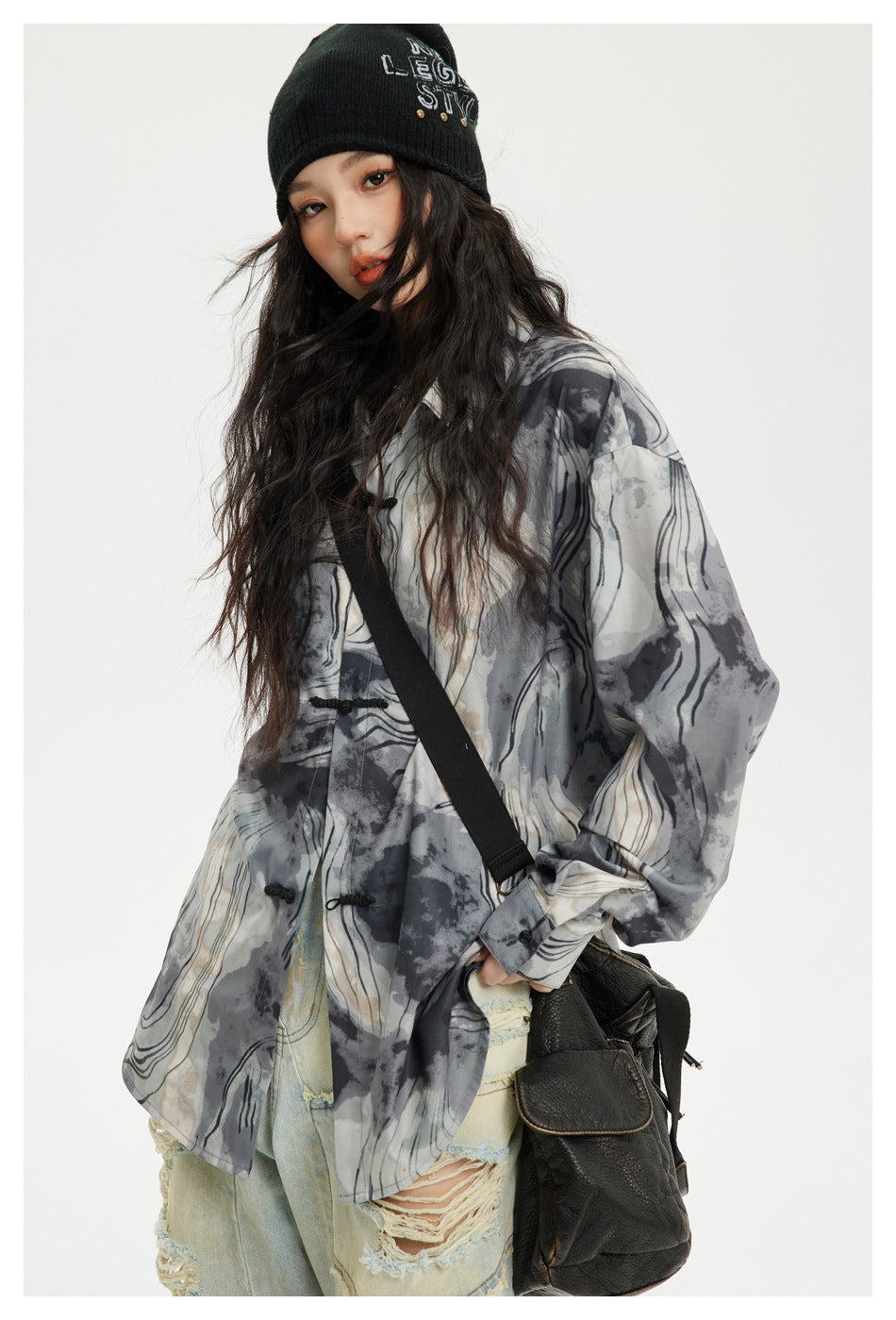 Model wearing a loose gray abstract-print shirt with black frog closures, shown at a slight angle.