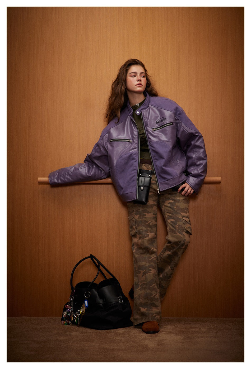 Full-length model wearing a purple zip jacket and camouflage cargo pants.