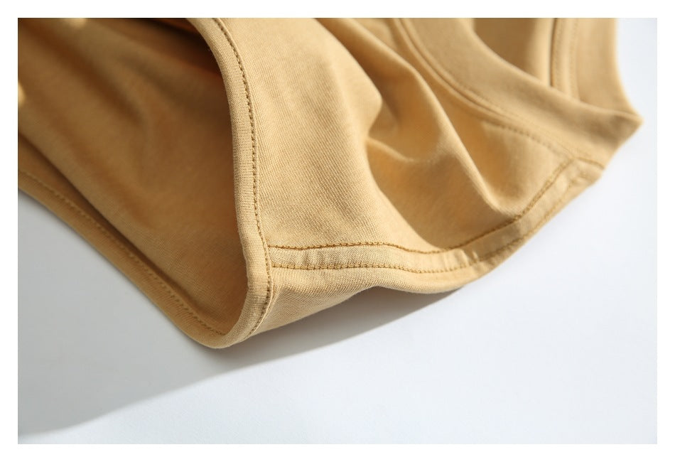 Close-up of the tan T-shirt's stitched armhole and garment seams.