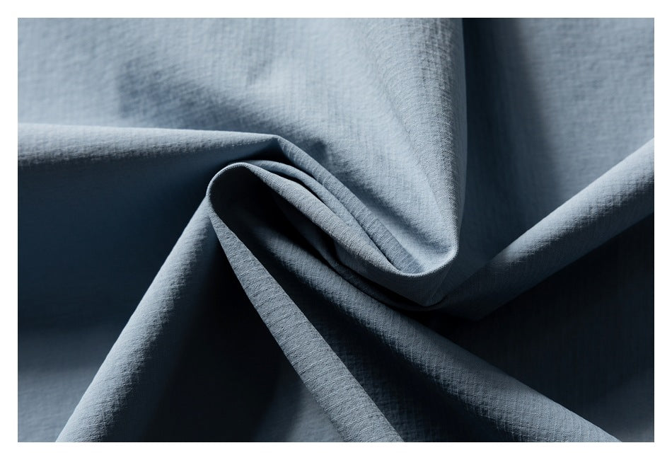 Blue-gray fabric draped in folds, showing its fine textured surface.