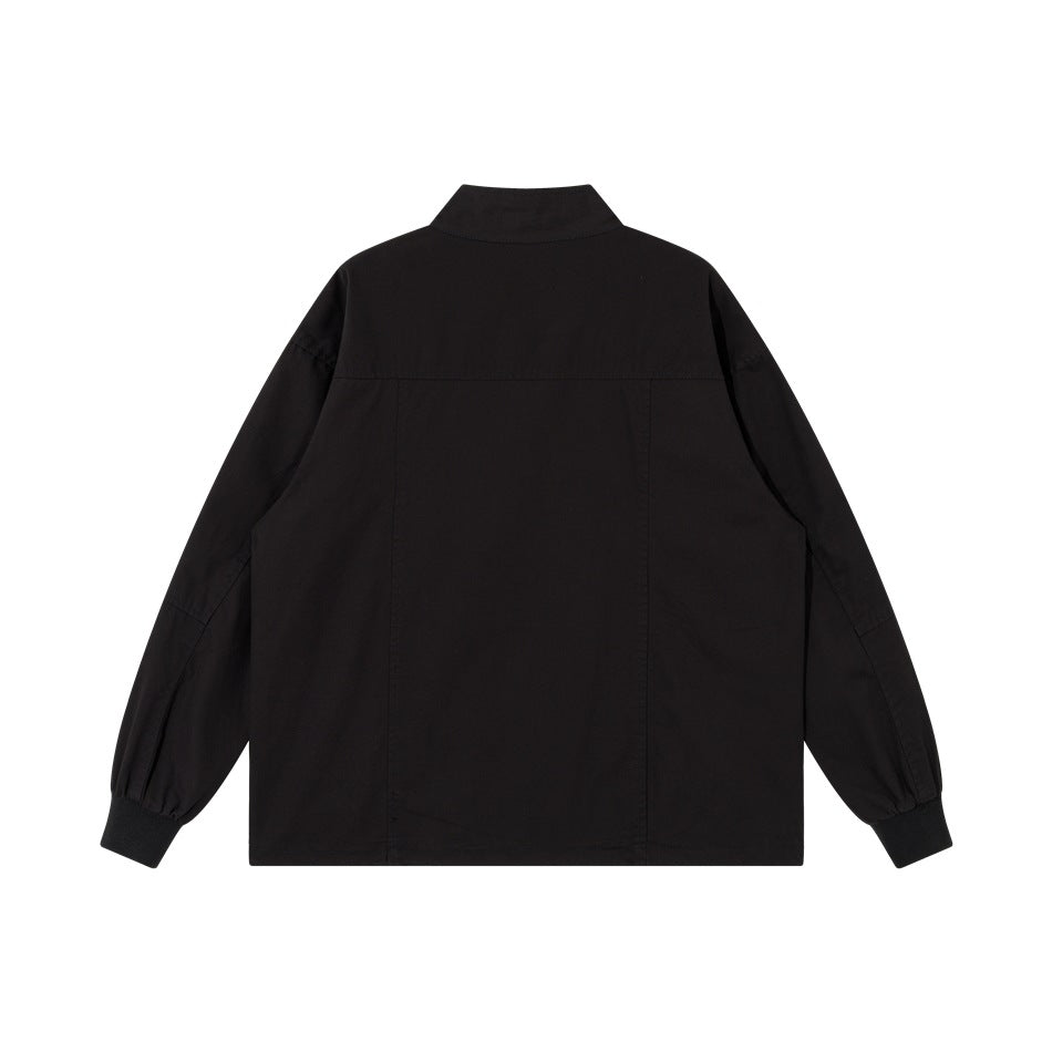 Black jacket back view with stand collar, back yoke seam, vertical panel seams and ribbed cuffs, flat lay