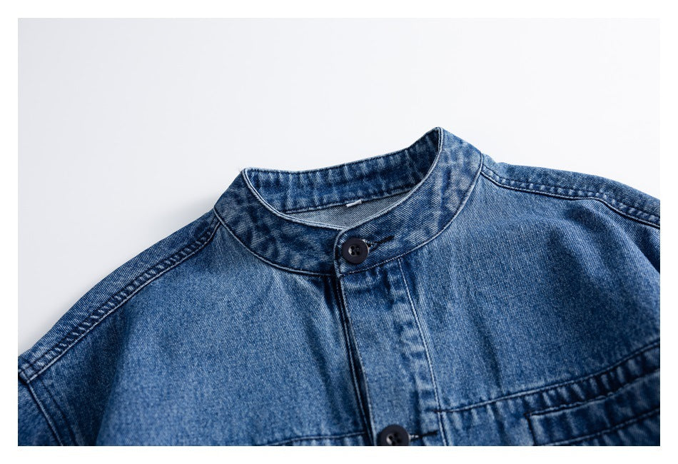Close-up of a blue denim jacket's stand collar and upper front with dark buttons.