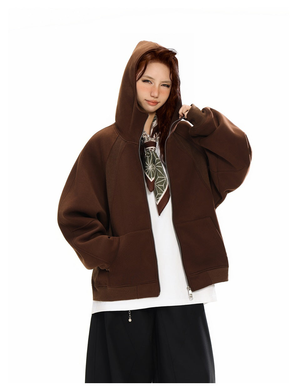 Model wearing a dark brown zip-up hoodie with the hood up and roomy front pockets.