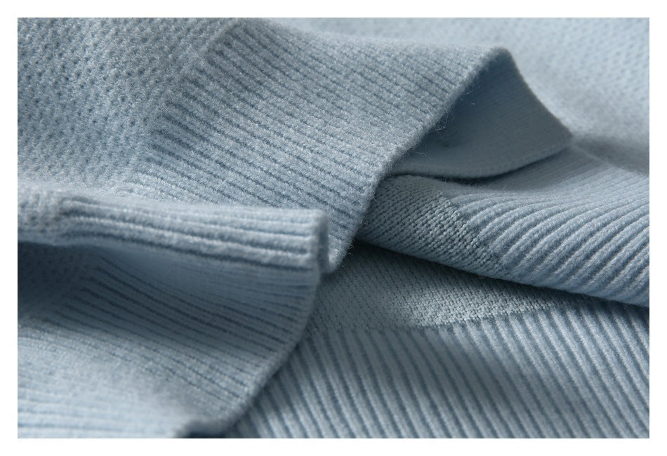 Close-up of pale blue knit cardigan fabric and folded ribbed edges.