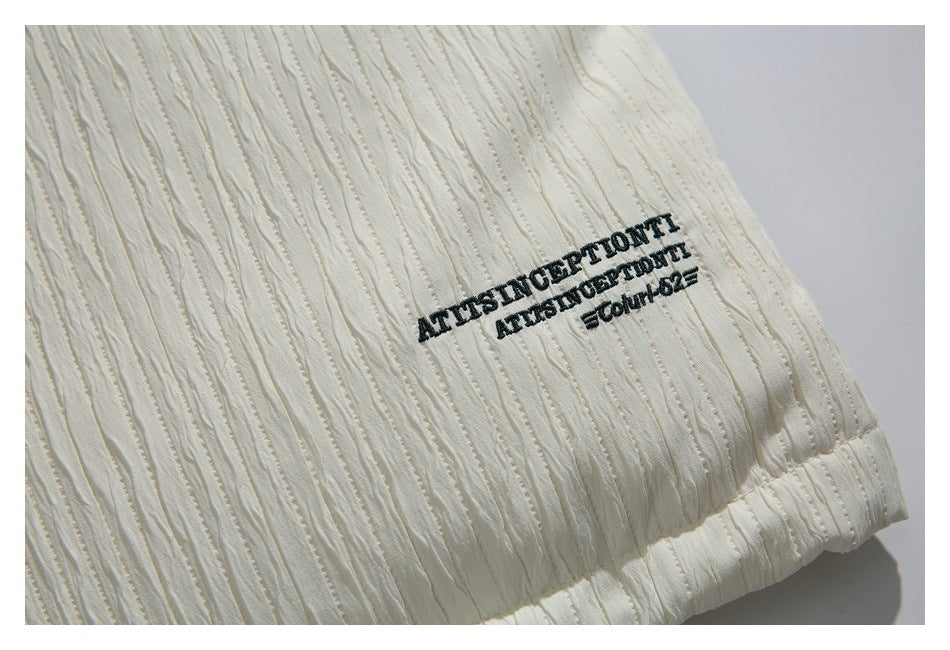 Black embroidered English lettering on the textured ivory jacket fabric.
