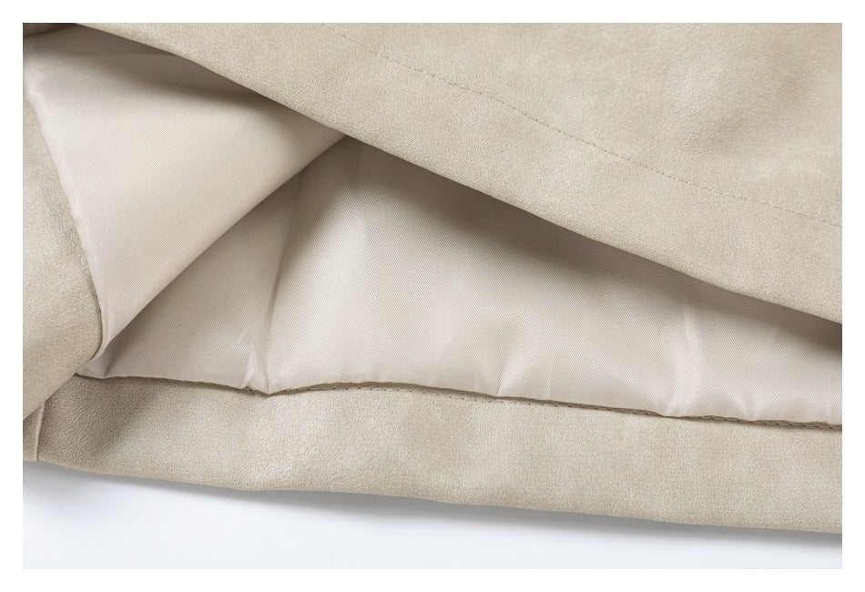 Close-up showing the light lining and stitched hem inside a taupe coat.