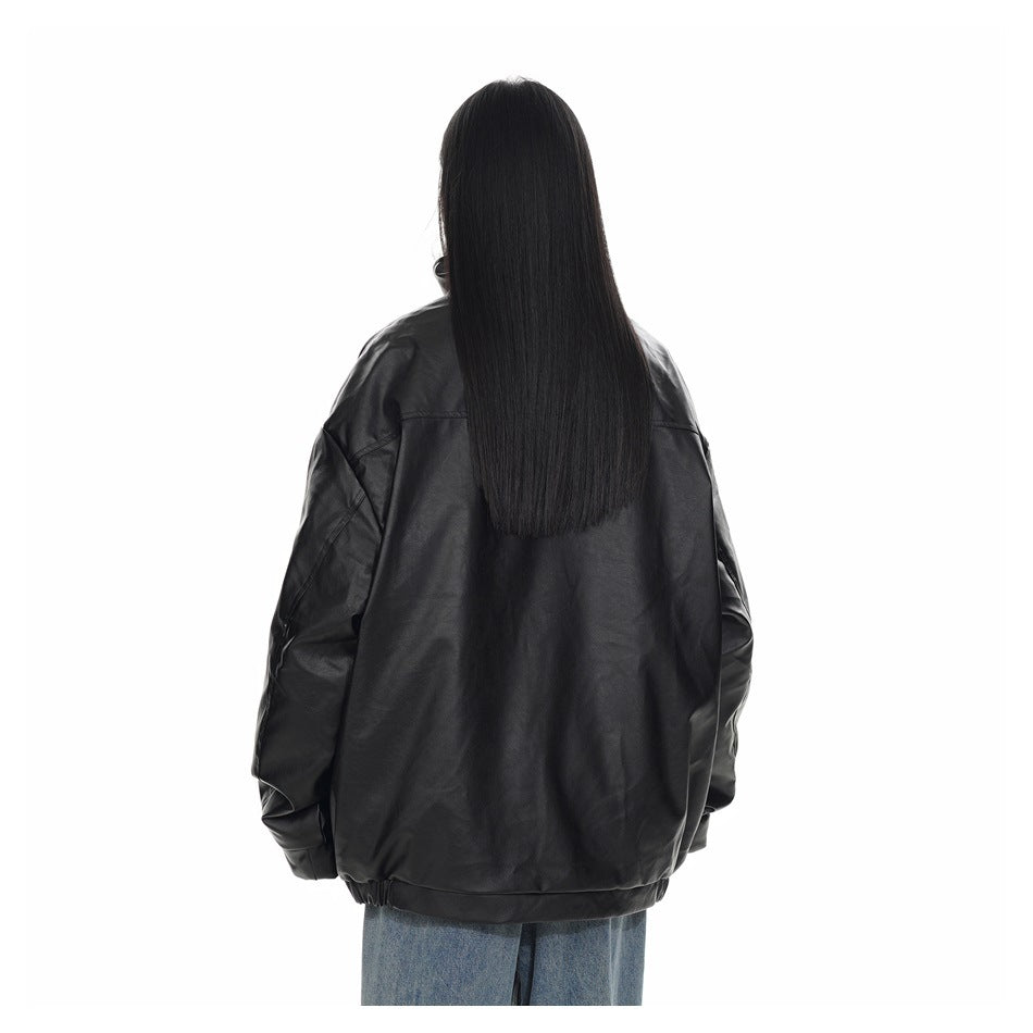 Rear view of a model wearing a black oversized jacket with a plain back and loose light blue jeans.
