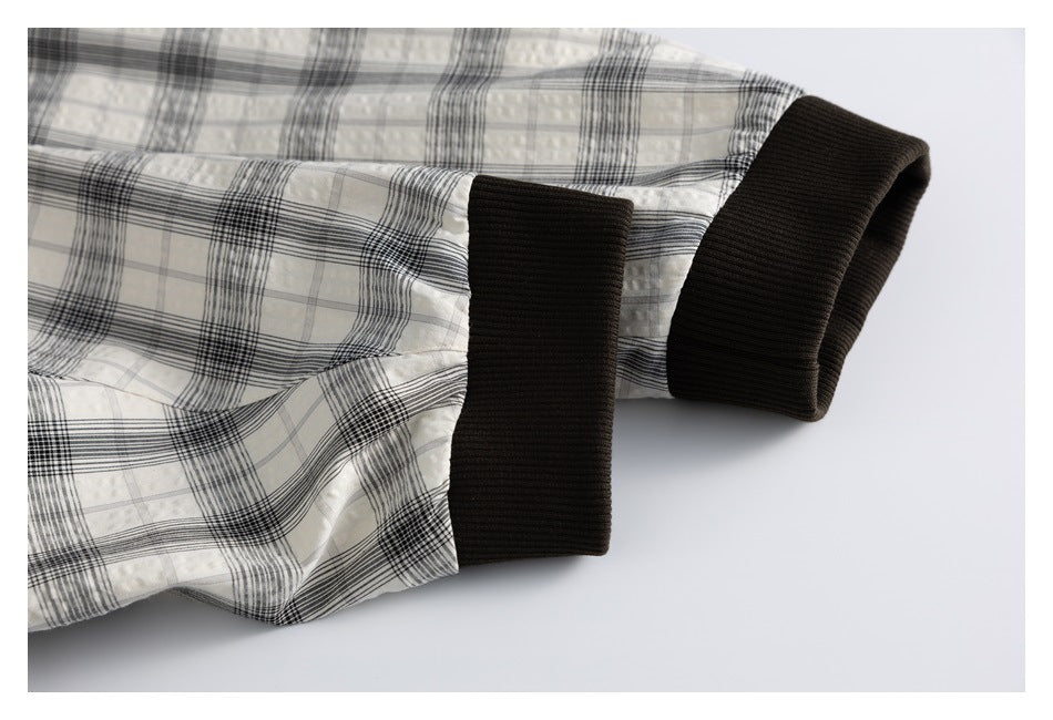 Close-up of the plaid jacket sleeves and their wide black ribbed cuffs.