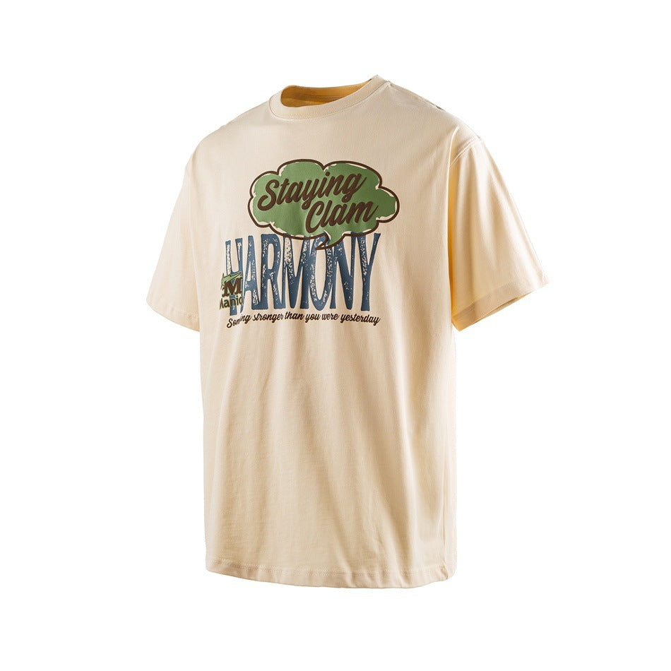 Light apricot short-sleeve T-shirt with green and blue Staying Clam HARMONY graphic, angled view