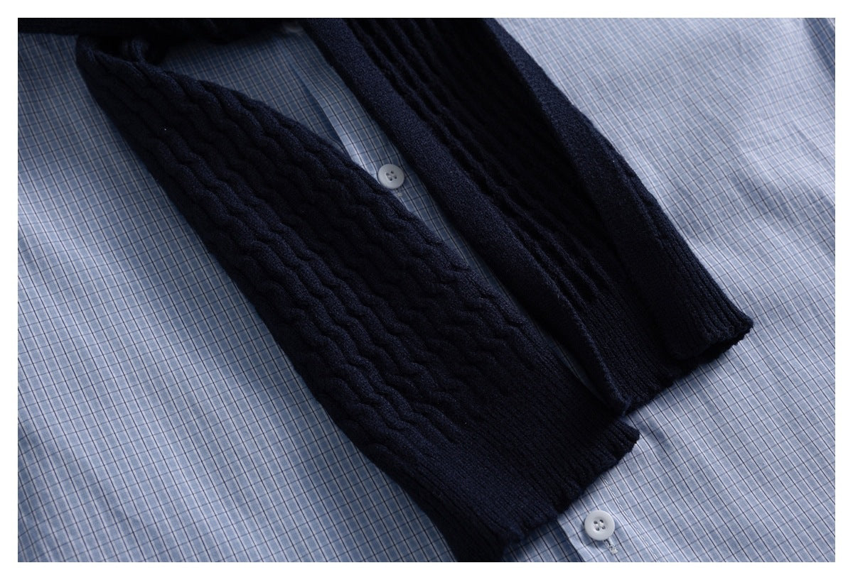 Dark navy knitted tie laid diagonally over a blue-and-white check shirt.