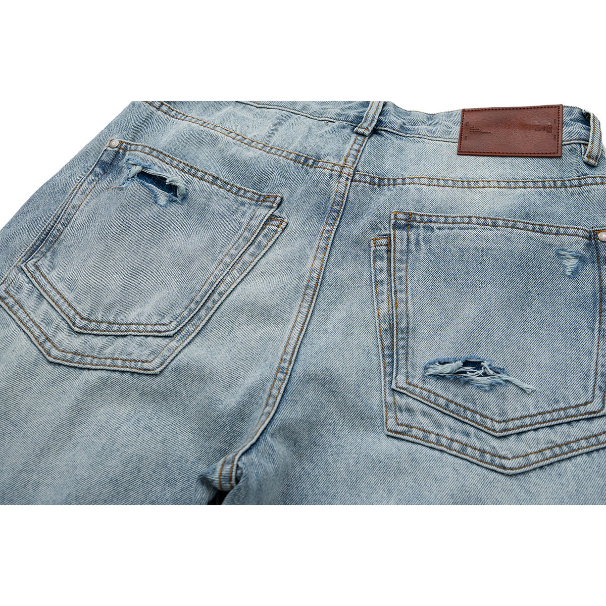 Close back view of light-wash jeans with two distressed pockets and a brown waistband patch.