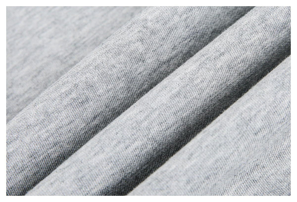Close-up of light gray knit fabric gathered into soft folds, showing its fine texture.