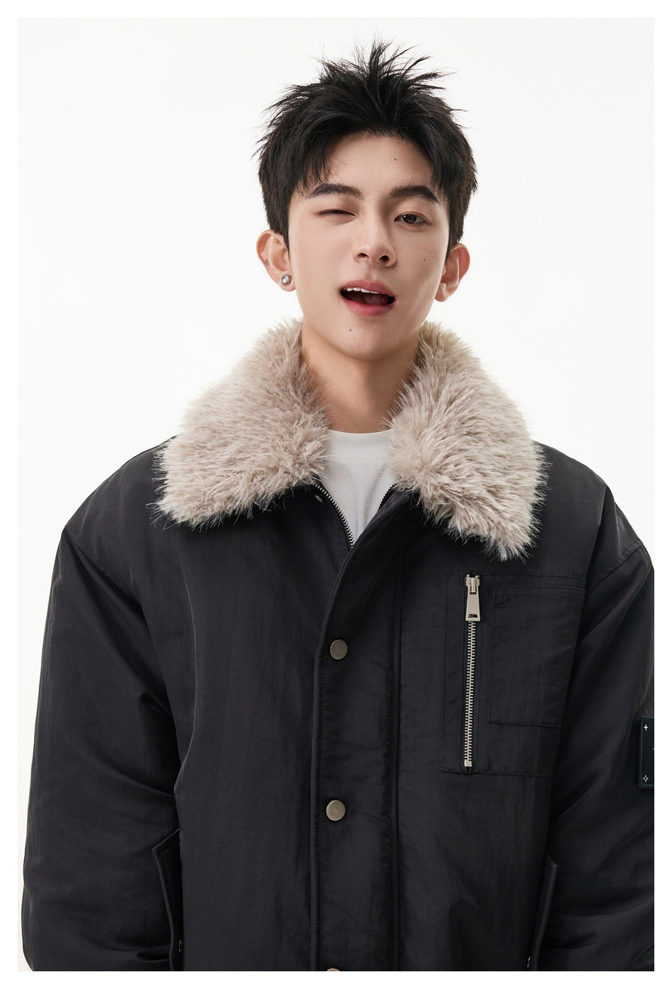 Close-up of a model wearing a black jacket with a plush light collar and vertical zippered chest pocket.