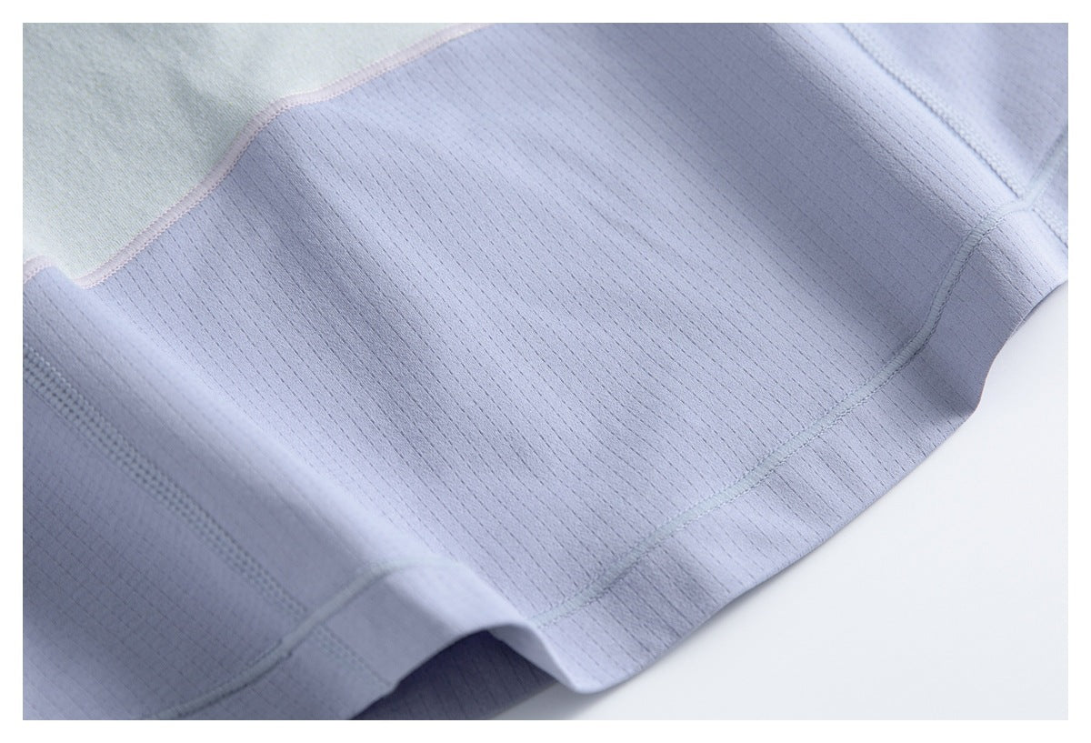 Close-up of pale lavender garment fabric with fine vertical texture, curved seams and subtle contrasting panels.
