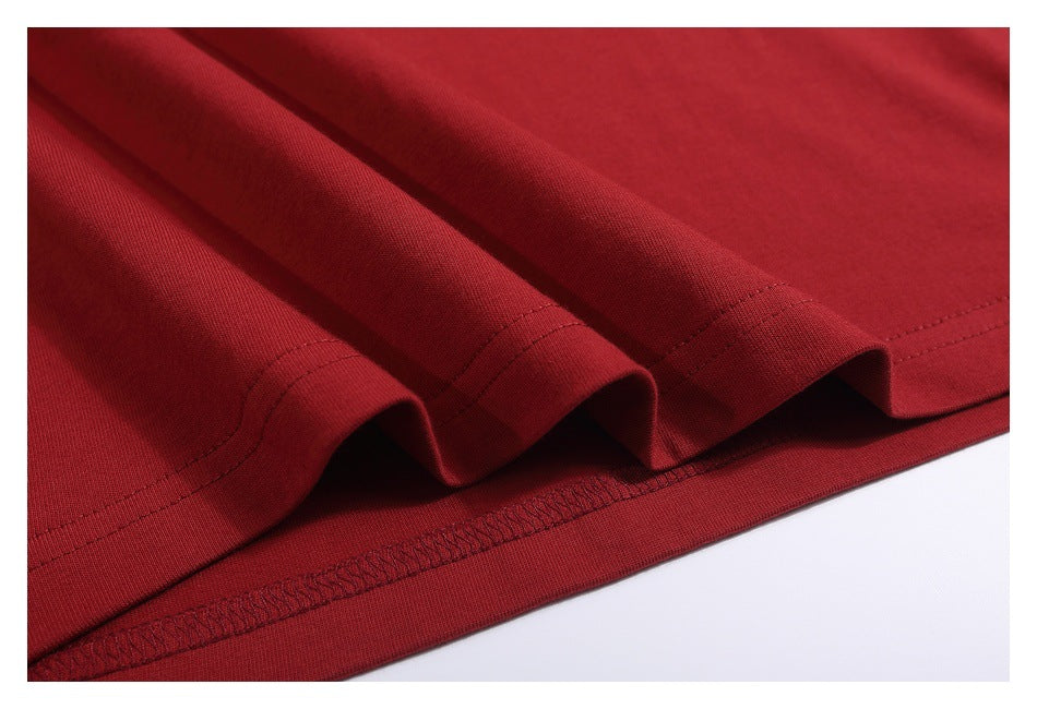 Close-up of the dark red T-shirt’s folded lower hem and overlocked seam.