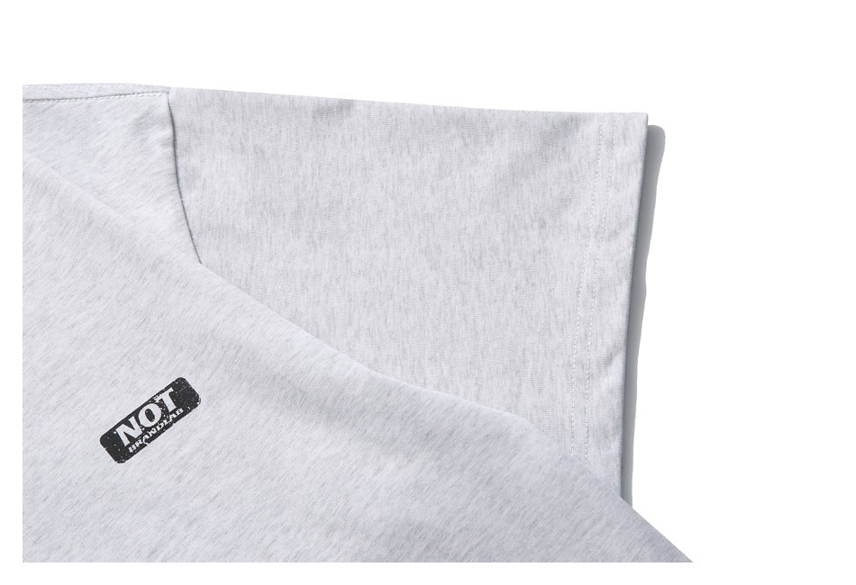 Close-up of the light gray heather T-shirt sleeve and shoulder seam with a small black chest logo.