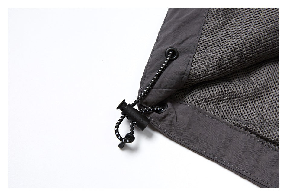 Close-up of dark mesh lining and an adjustable drawcord with a toggle at the garment edge.
