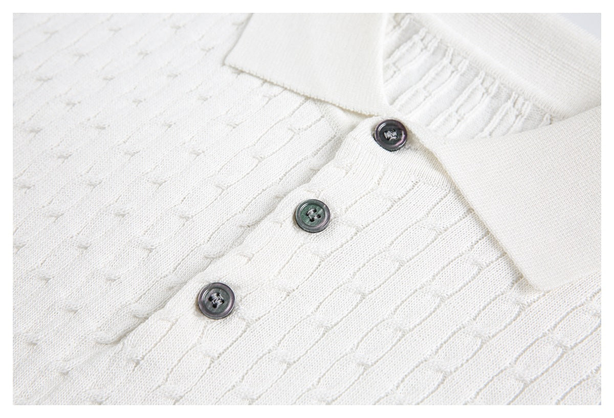 Close-up of three dark buttons on the textured placket of an ivory knit polo shirt.