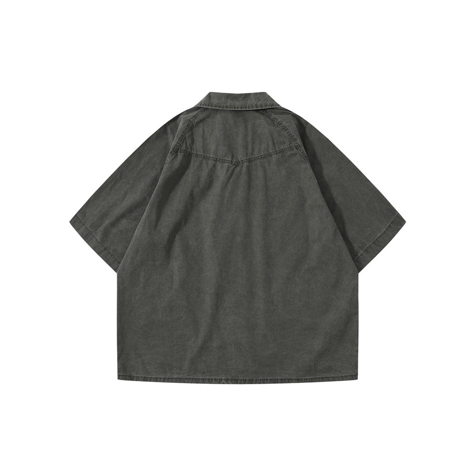Back view of dark gray washed short-sleeve shirt with yoke seam and raglan-style sleeves, flat lay