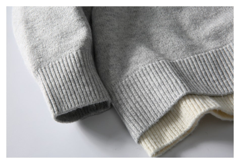 Close-up of the gray sweater's ribbed sleeve cuff and hem, with cream ribbed trim beneath.