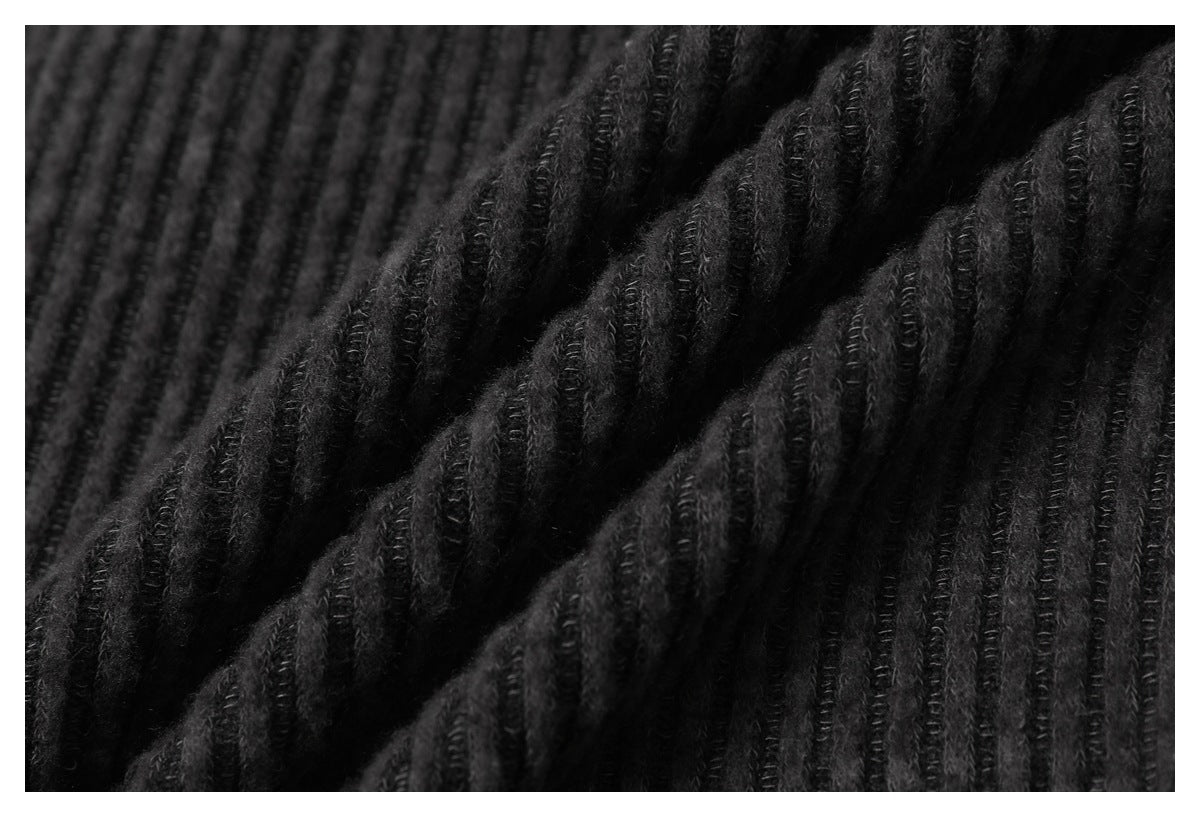 Close-up of black fabric with raised vertical ribs and soft diagonal folds.