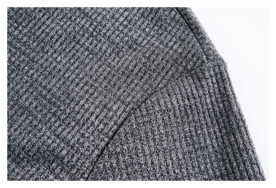 Close-up of a seam and textured knit fabric on a charcoal gray garment.