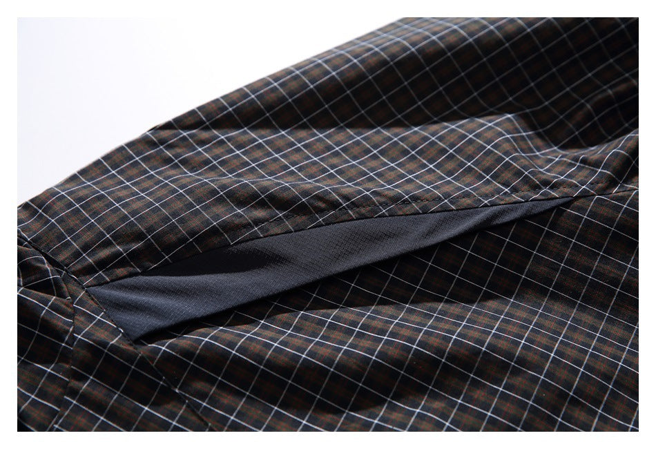 Close view of a dark inner panel beneath the plaid jacket fabric.