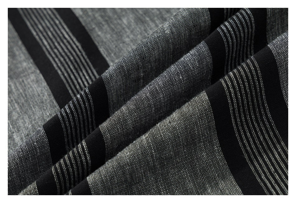 Close-up of the black and gray striped shirt fabric arranged in soft folds.