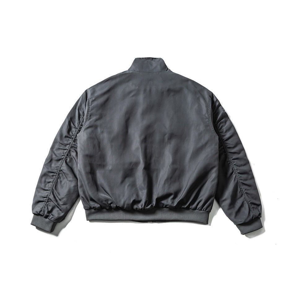 Back view of blue-gray bomber-style jacket with stand collar, ruched sleeves and ribbed hem and cuffs