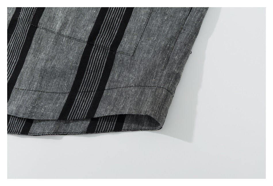 Close-up of the hem and stitching on the black and gray striped shirt.