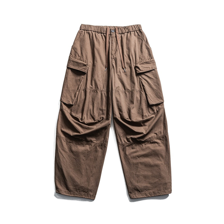 Camel brown wide-leg cargo pants with elastic drawstring waist and large side flap pockets, flat front view