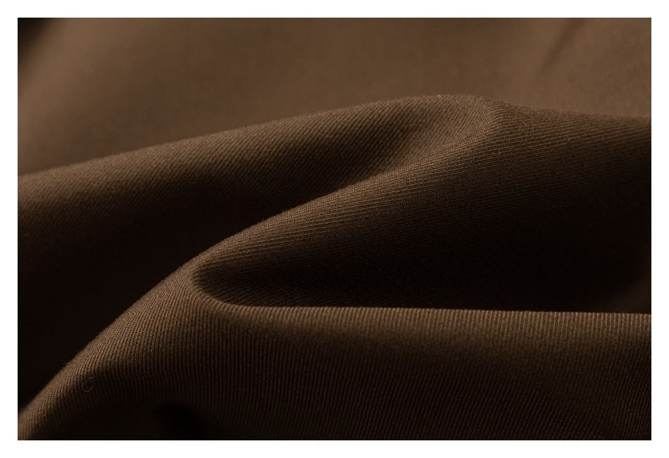 Close-up of brown fabric draped in folds, showing its surface texture.