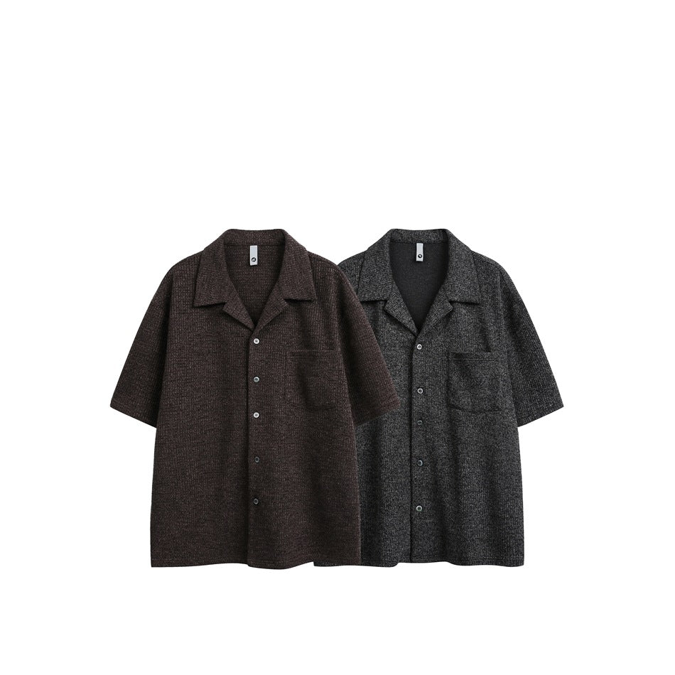 Two short-sleeve button-up shirts shown in brown and charcoal gray, each with a notched collar and chest pocket.
