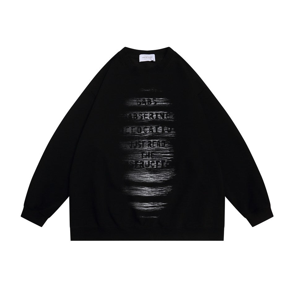 Black crewneck sweatshirt flat lay with distressed stencil-style text graphic on the front and ribbed cuffs